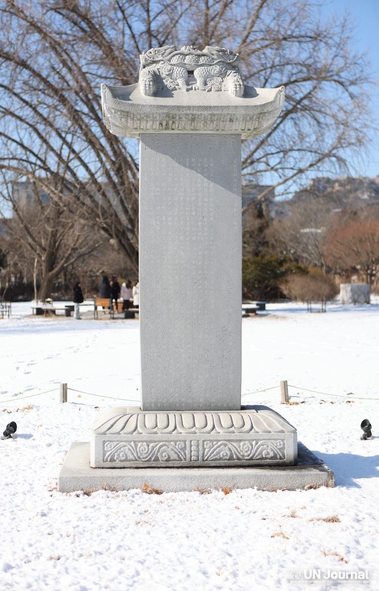 A replica of the Bukgwandaecheopbi stands on the lawn square of the Gyeongbokgung National Palace Museum.
