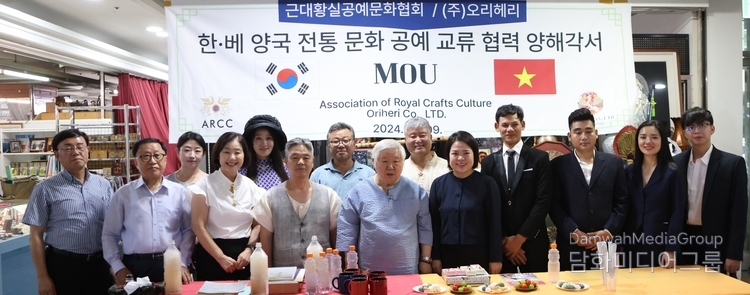 Lee Chil-yong, president of the Association of Royal Crafts Culture (left), and Tran Thi Ngoc Diep, chairwoman of ORIHERI, (7th and 5th from the right, respectively) take a group photo at a signing ceremony held at the Janggyo Building in Seoul on Aug. 9.