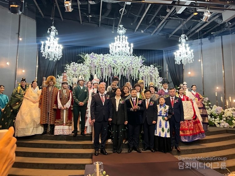 Ambassador Nurgali Arystanov of Kazakhstan takes a commemorative photo with participants in the Kazakh traditional fashion show.
